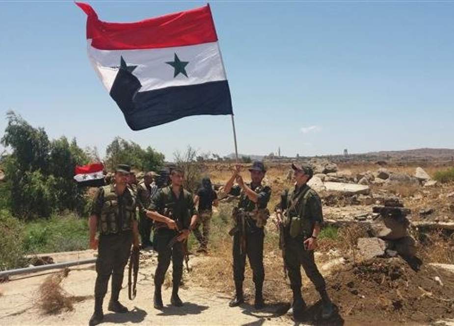 This handout picture released by the official Syrian Arab News Agency (SANA) on July 26, 2018 shows Syrian army soldiers carrying the national flag in the village of Hamidiyah in the southern province of Quneitra.