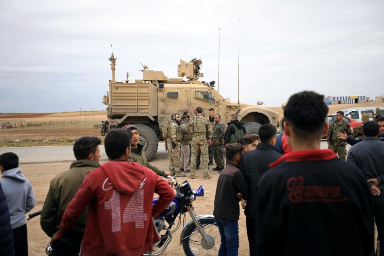 Syrian residents watch as U.S. troops patrol near Turkish border in Hasakah, November 4, 2018.
