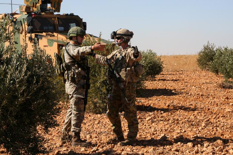 U.S. and Turkish soldiers discuss details during the first-ever combined joint patrol in Manbij, November 1, 2018.