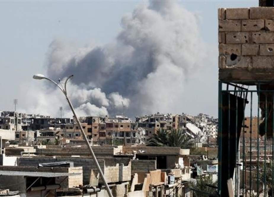 In this file picture, smoke rises near the stadium where Daesh Takfiri militants are purportedly holed up after a US-led airstrike at the frontline, in Raqqah, Syria. (Photo by Reuters)