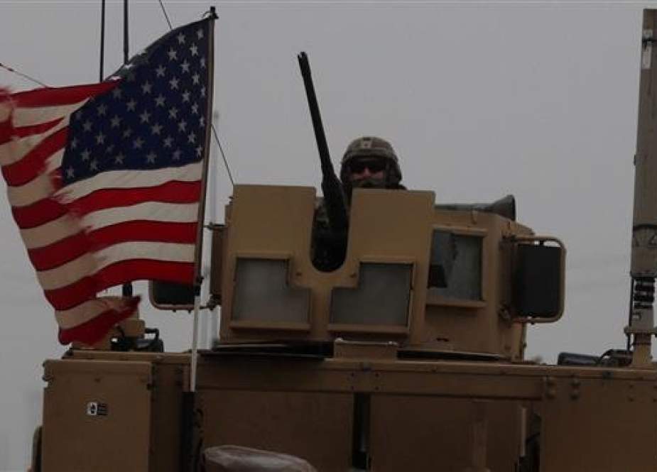 A picture taken on December 30, 2018, shows a US soldier riding an armored personnel carrier as a line of US military vehicles patrol in Syria. (Photo by AFP)