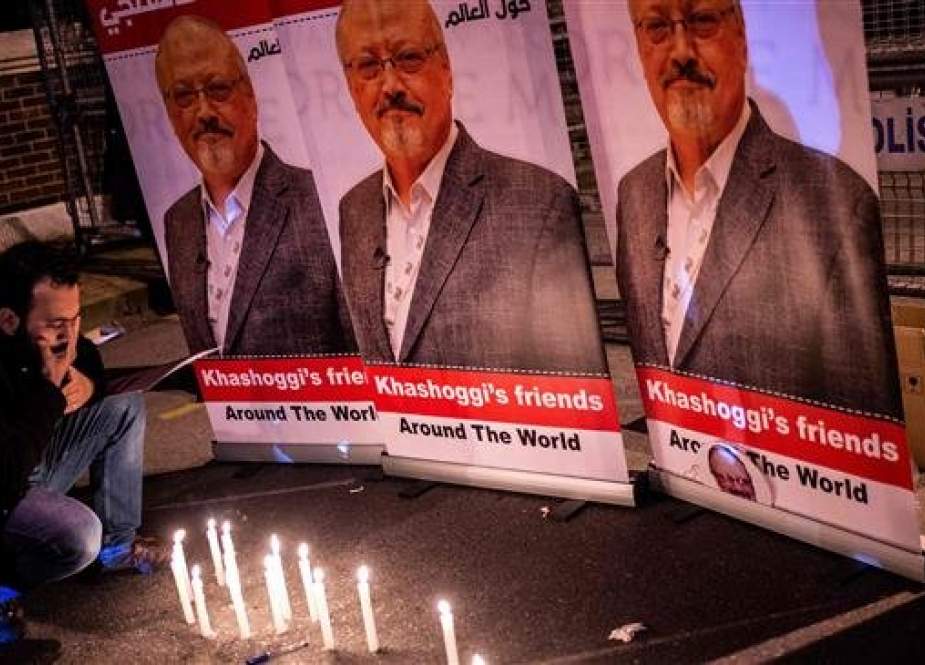 A man mourns by a makeshifts memorial made of candles and posters picturing late Saudi journalist Jamal Khashoggi during a gathering outside the Saudi Arabia consulate in Istanbul on October 25, 2018. (Photo by AFP)