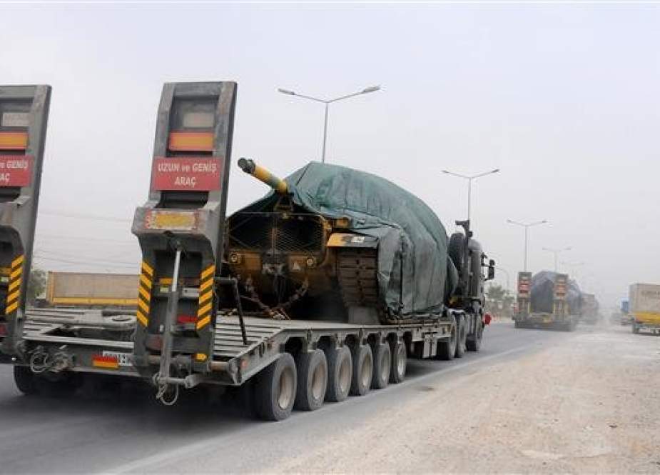 Turkish military truck carries tanks as it drives towards the Syrian border in Hatay, southern Turkey.jpg
