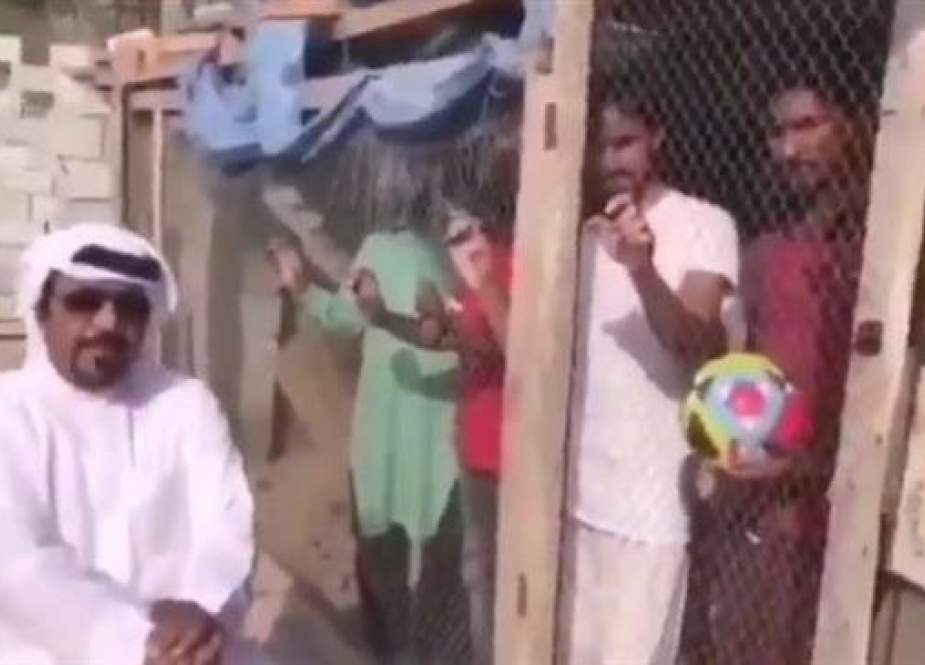 This video grab shows an Emirati national sitting outside a large bird cage where eight Asian male workers are barricaded.