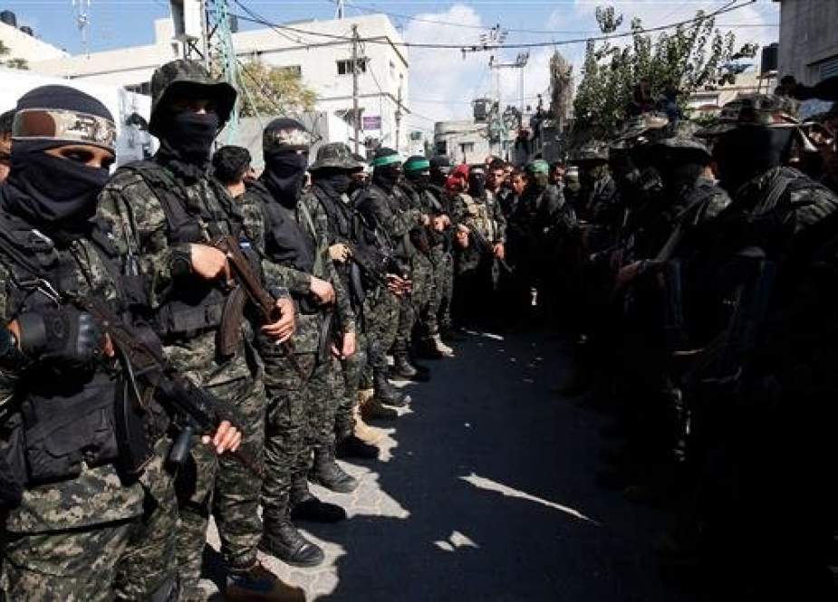 Fighters from the Hamas military wing, Ezzedine al-Qassam Brigades, attend the funeral of a Palestinians killed during an Israeli raid on the Gaza Strip, in Khan Yunis on November 12, 2018. (Photo by AFP)