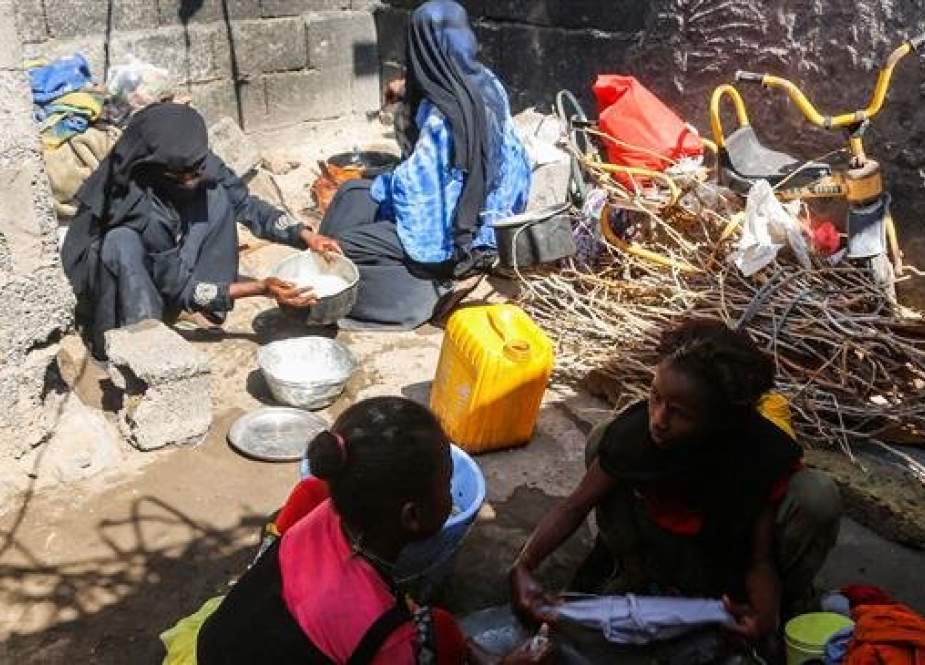 Yemeni women from a poor family prepare food for cooking as other girls wash clothes in a metal basin in a shack in the embattled Red Sea port city of Hudaydah on January 11, 2019. (Photo by AFP)