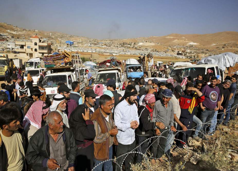 Syrian refugees gather in and near their vehicles getting ready to cross into Syria from the eastern Lebanese border town of Arsal, Lebanon, on June 28, 2018. (Photo by the Associated Press)