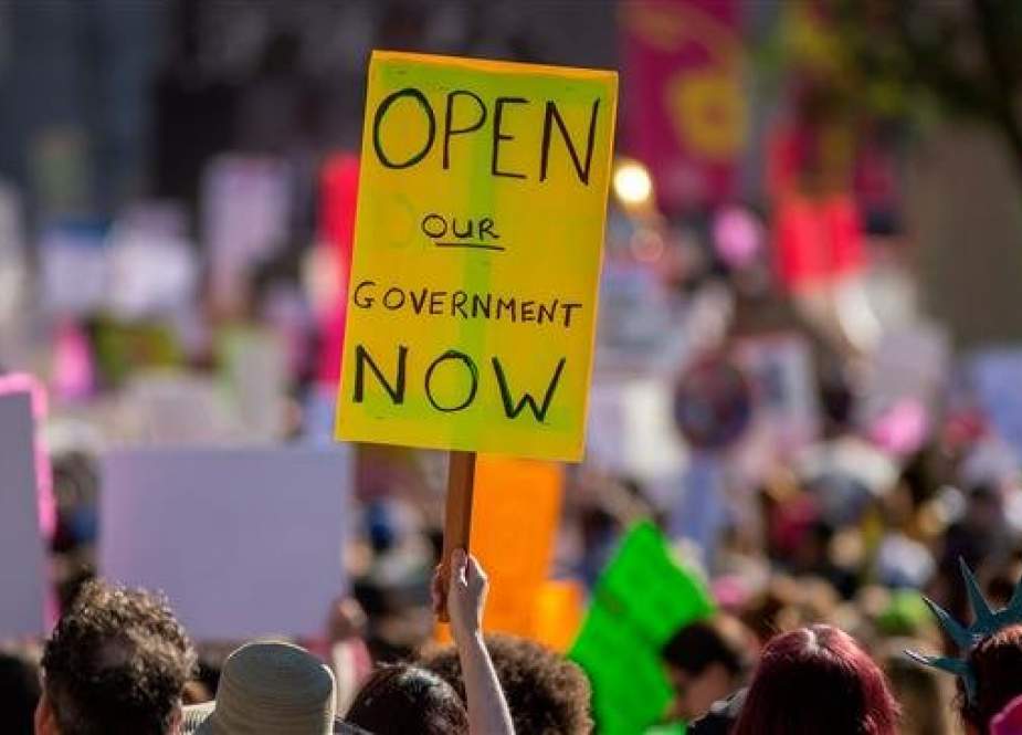 A placard calls for an end to the partial government shutdown during the Third Annual Women