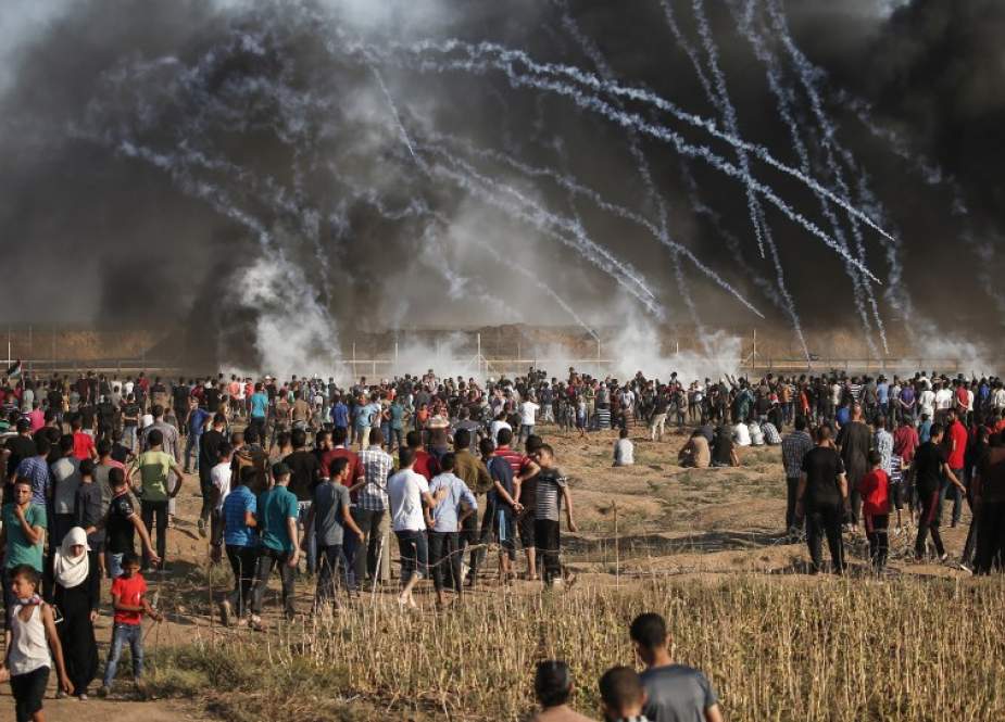 Palestinian protesters run away from teargas canisters during clashes with Israeli forces following a demonstration along the Gaza border east of Gaza City on January 18, 2019. (Photo by AFP)