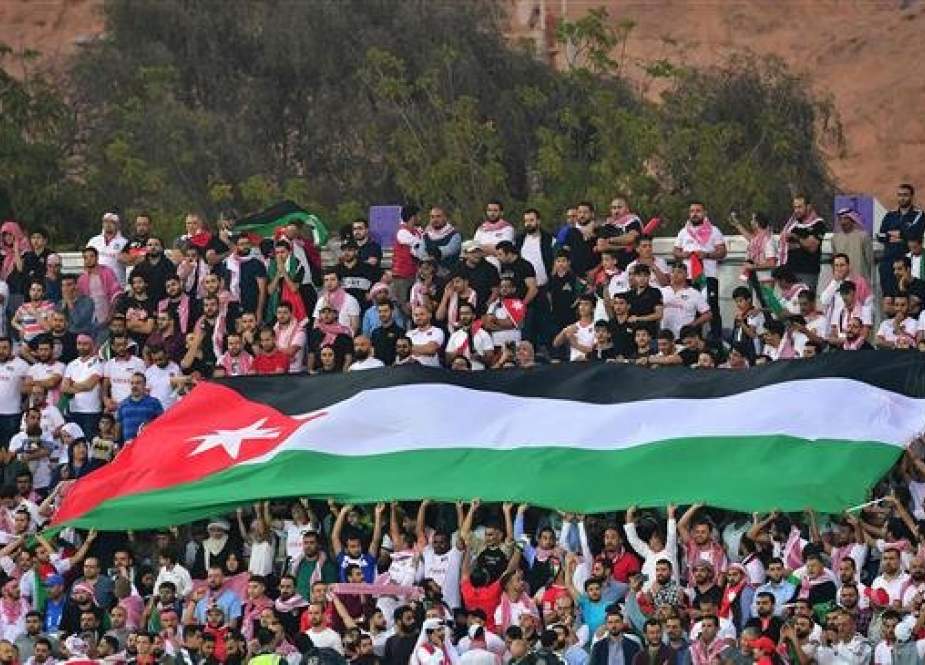 Jordan supporters wave the national flag during the 2019 AFC Asian Cup Group B football match between Jordan and Syria at the Khalifa bin Zayed stadium in al-Ain, the United Arab Emirates (UAE), on January 10, 2019. (Photo by AFP)