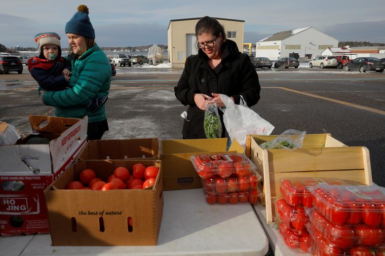 Members of the U.S. Coast Guard working without pay during the government shutdown and their families pick up produce, eggs, milk, bread and other supplies being distributed by Gather food pantry at the Coast Guard Portsmouth Harbor base in New Castle, N