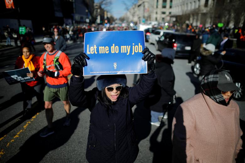 Federal government employees, contract workers and other demonstrators march during a 