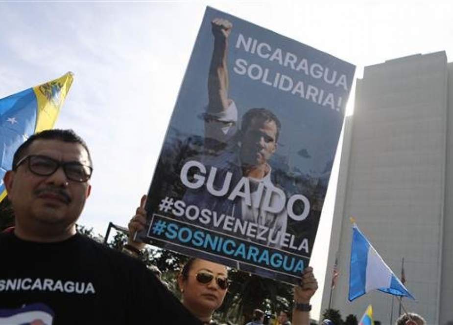 Anti-Maduro demonstrators gather as one holds a poster of Venezuelan opposition leader Juan Guaido, outside the Federal Building, on January 26, 2019 in Los Angeles, California. (Photo by AFP)