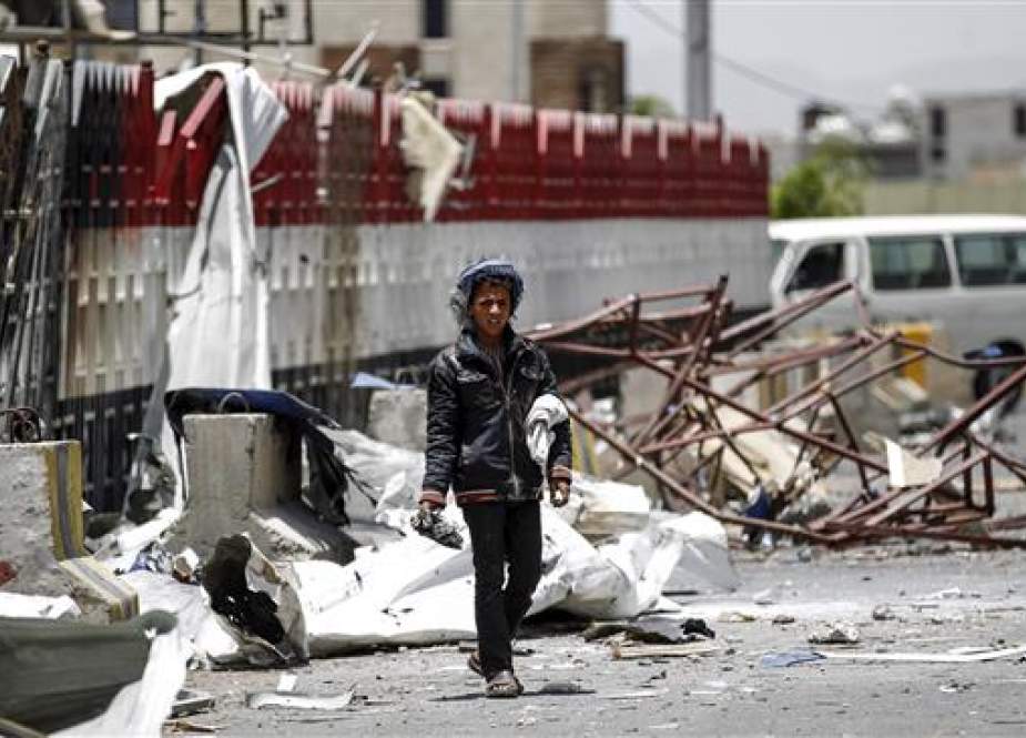 Yemeni boy walks through the rubble and debris.jpg