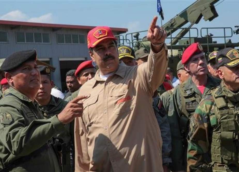 A handout picture released by the Venezuelan presidency shows Venezuela’s President Nicolas Maduro (C) speaking to a commander during military exercises at the Naval Base Agustin Armario in Puerto Cabello, Carabobo State, Venezuela, on January 27, 2019. (Via AFP)