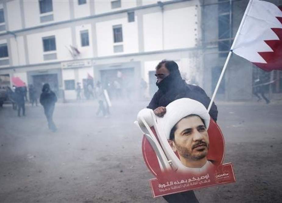 Bahraini protester carrying a placard showing Sheikh Ali Salman.jpg