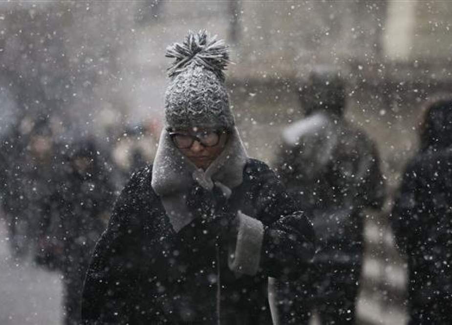 Pedestrians walk through the falling snow in the Financial District in New York City.jpg