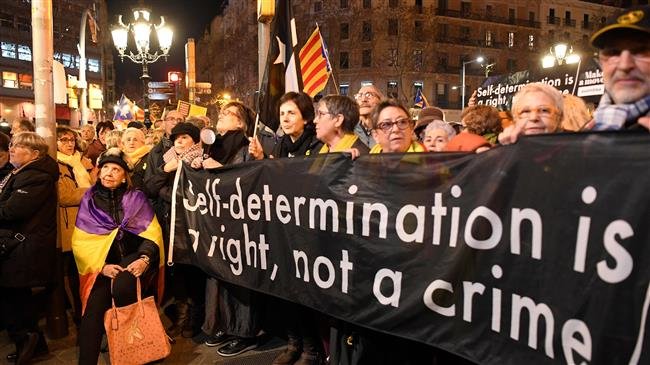 Protesters holding a banner reading, "Self determination is a right, not a crime", in Barcelona on February 1, 2019, during a demonstration in support of jailed Catalan pro-independence leaders (AFP)