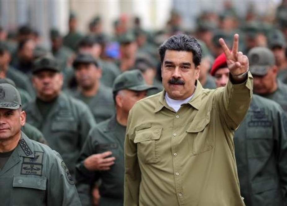 This handout picture released by the Venezuelan Presidency shows President Nicolas Maduro (R) flashing the V-sign during a military rally at Fuerte Tiuna Military Complex in Caracas on January 30, 2019. (Via by AFP)