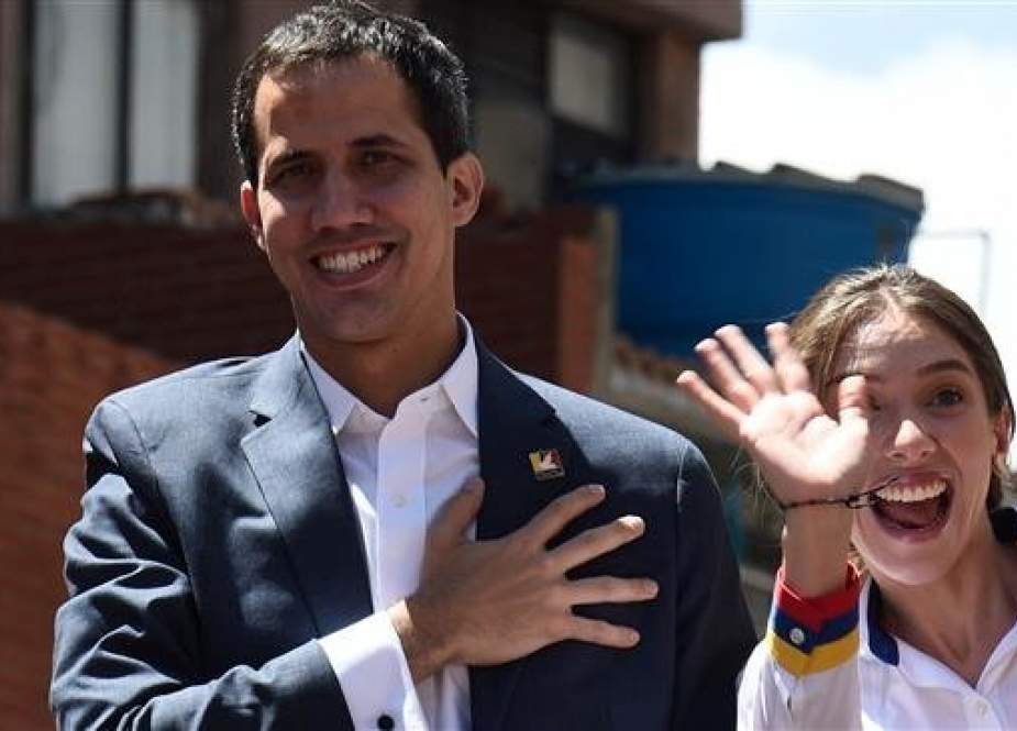 Venezuelan opposition leader and self declared acting president Juan Guaido (L), accompanied by his wife Fabiana Rosales, gestures at supporters upon arriving at a rally to press the military to let in US humanitarian aid, in eastern Caracas on February 12, 2019. (AFP)