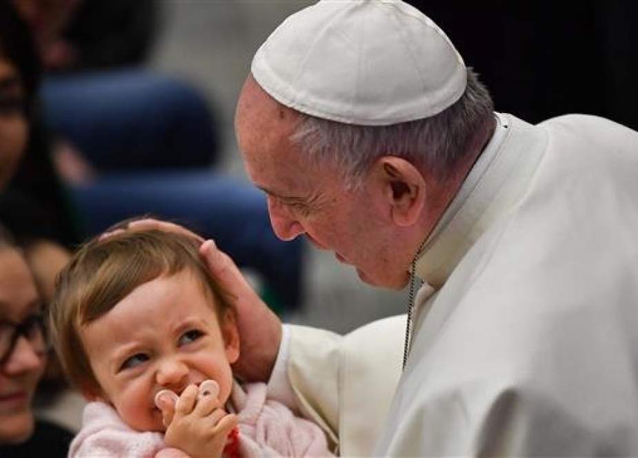 Pope Francis blesses a child during the weekly general audience.jpg