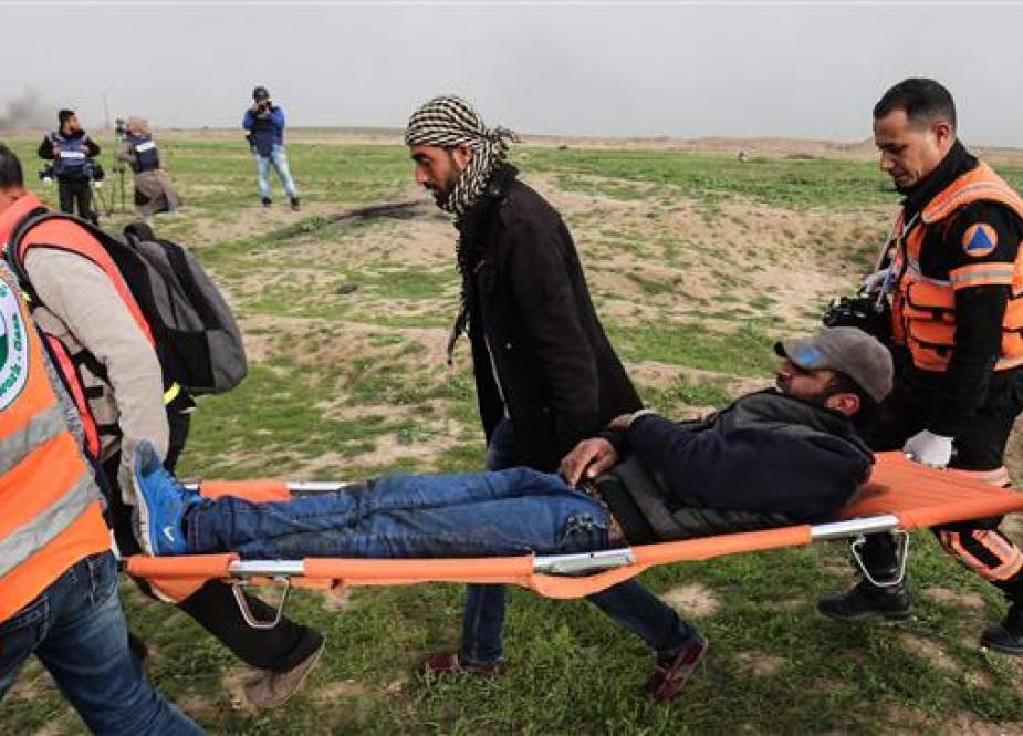 Palestinian medics help evacuate a wounded protester during clashes with Israeli forces following a demonstration near the fence along the border with Israel, east of Gaza City, on February 15, 2019. (AFP)
