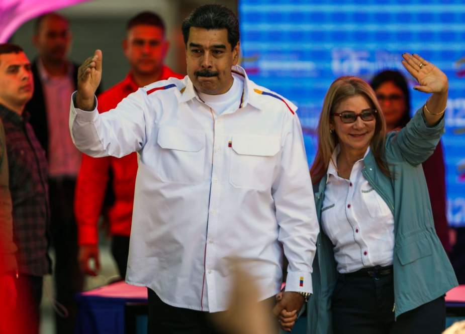 Presiden Venezuela Nicolás Maduro dan istrinya, Cilia Flores, melambaikan kepada para pendukung di Caracas pada hari Selasa (Orangel Hernandez / Agence France-Presse )