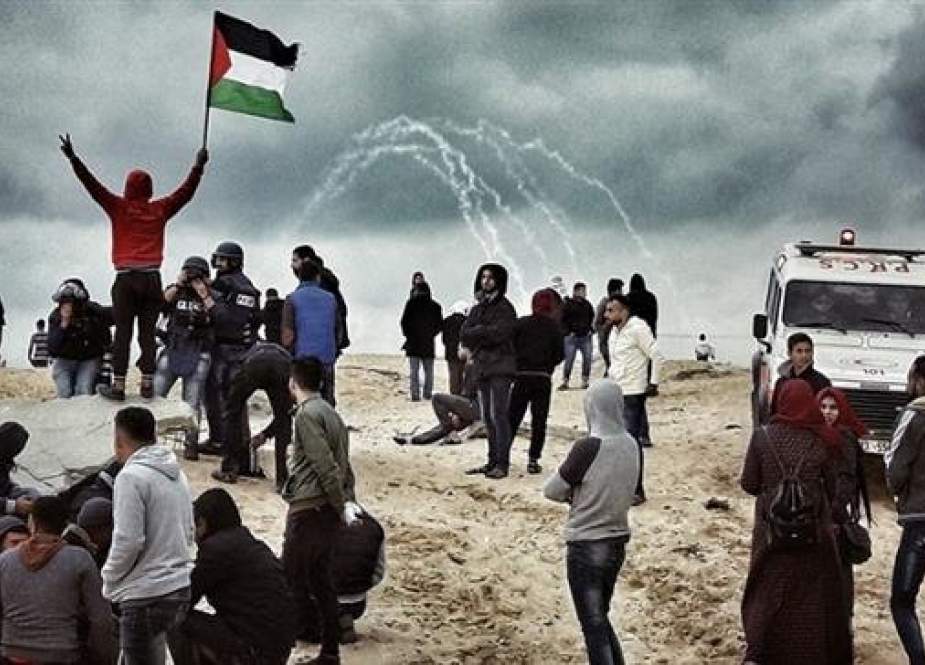 A Palestinian protester waves a national flag as people participate in a demonstration on the beach near the maritime border with the Israeli-occupied territories, in the northern Gaza Strip, on February 19, 2019.