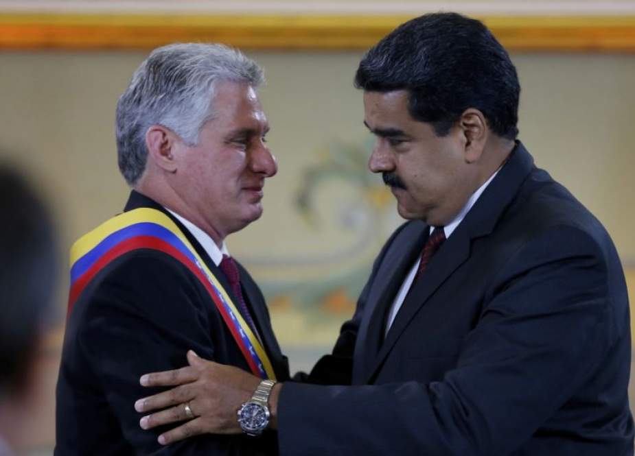 Presiden Kuba Miguel DIaz-Canel, kiri, dipeluk oleh timpalannya dari Venezuela Nicolas Maduro setelah dianugerahi "Orden del Libertador Simon Bolivar," di Istana Presiden Miraflores di Caracas, Venezuela, 30 Mei 2018. (voanews)