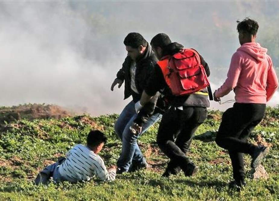 Palestinian protesters and a medic run to pick up a child during a demonstration east of Gaza City, February 22, 2019. (Photo by AFP)