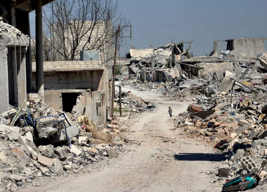 A Kurdish boy, center background, walks between buildings that were destroyed during the battle between the U.S. backed Kurdish forces and the Islamic State fighters, in Kobani, north Syria.