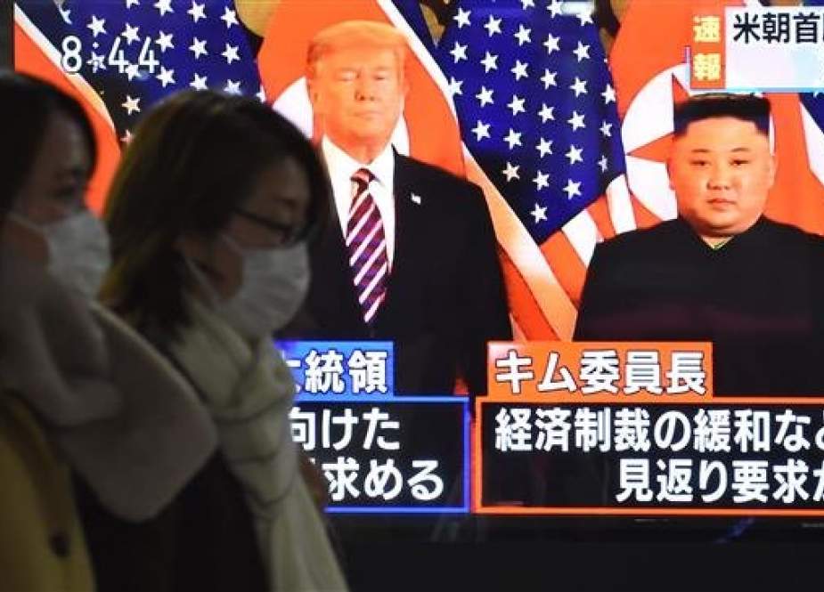Pedestrians walk past a television screen showing a news broadcast on the summit meeting between North Korean leader Kim Jong Un and US President Donald Trump in Hanoi, on February 27, 2019 in Tokyo. (AFP photo)