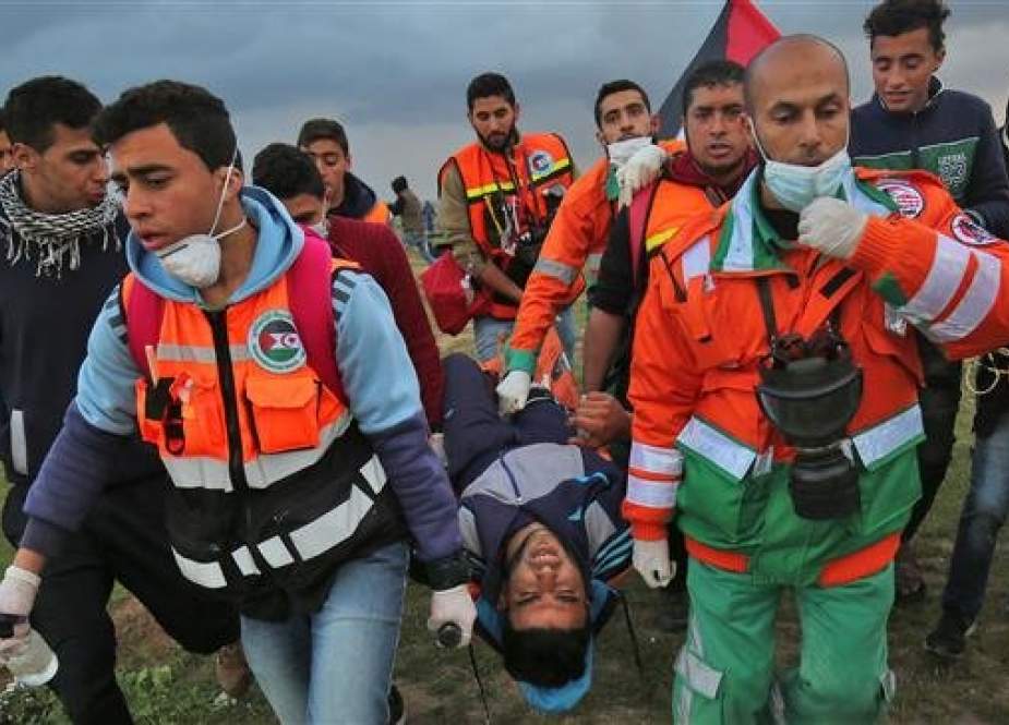 Palestinian paramedics carry a youth injured during clashes with Israeli forces, east of Gaza City, on March 1, 2019. (Photo by AFP)