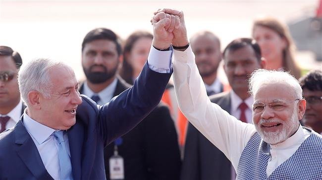 Israeli Prime Minister Benjamin Netanyahu and his Indian counterpart Narendra Modi raise their arms upon Netanyahu’s arrival at Air Force Station Palam in New Delhi, January 14, 2018.