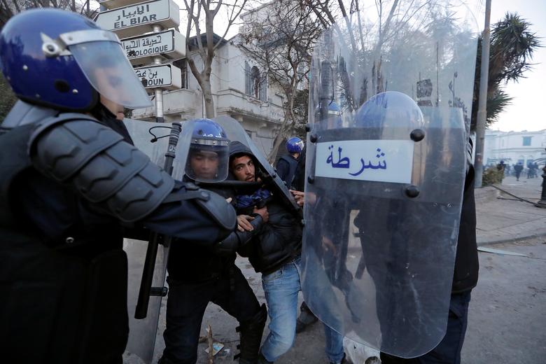 Anti-riot police officers detain a man who was protesting against President Abdelaziz Bouteflika's plan to extend his 20-year rule by seeking a fifth term in April elections in Algiers, Algeria, March 1