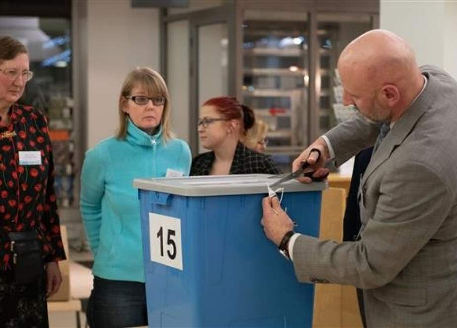 Electoral officials prepare to count ballots at a polling station during Estonia