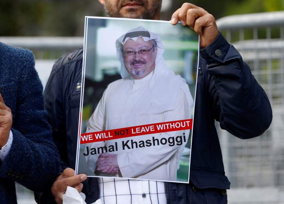 A demonstrator holds a picture of Saudi journalist Jamal Khashoggi during a protest in front of Saudi Arabia