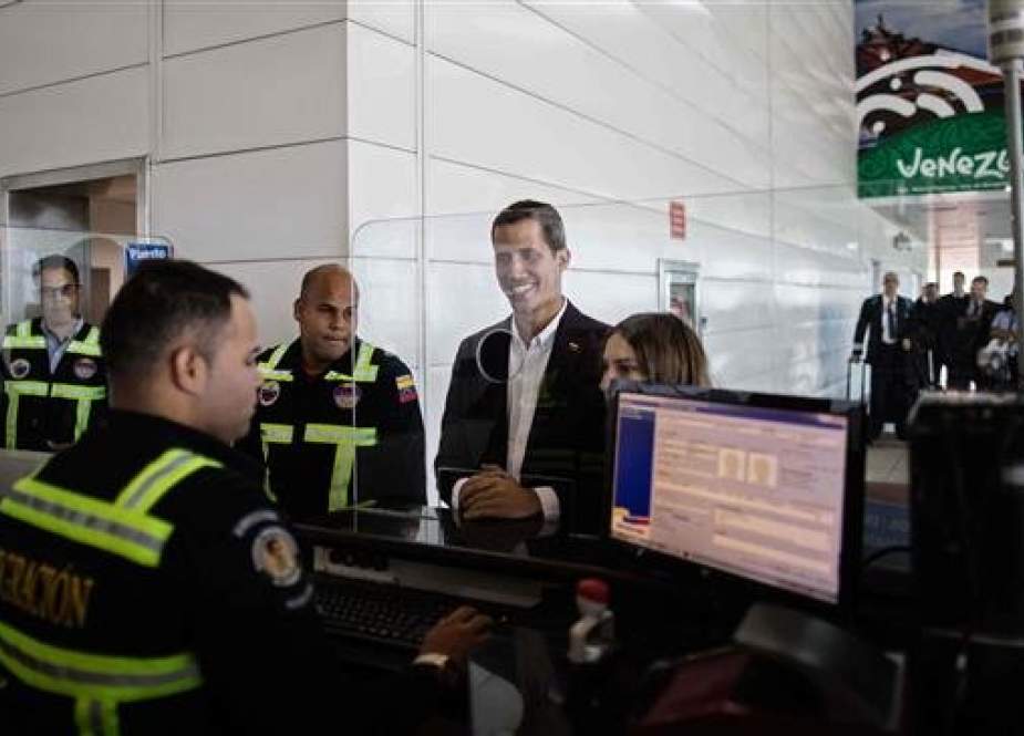 A photo released by Venezuelan opposition figure Juan Guaido shows him checking passports at the migrations office of the International Simon Bolivar airport on arrival in Maiquetia, Vargas State, Venezuela, on March 4, 2019. (Via AFP)
