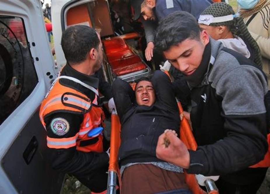 A file photo of Palestinian paramedics transporting into an ambulance a stretcher-ridden Gazan youth who was injured during clashes following a demonstration along the border with the occupied territories on March 1, 2019 (Photo by AFP)