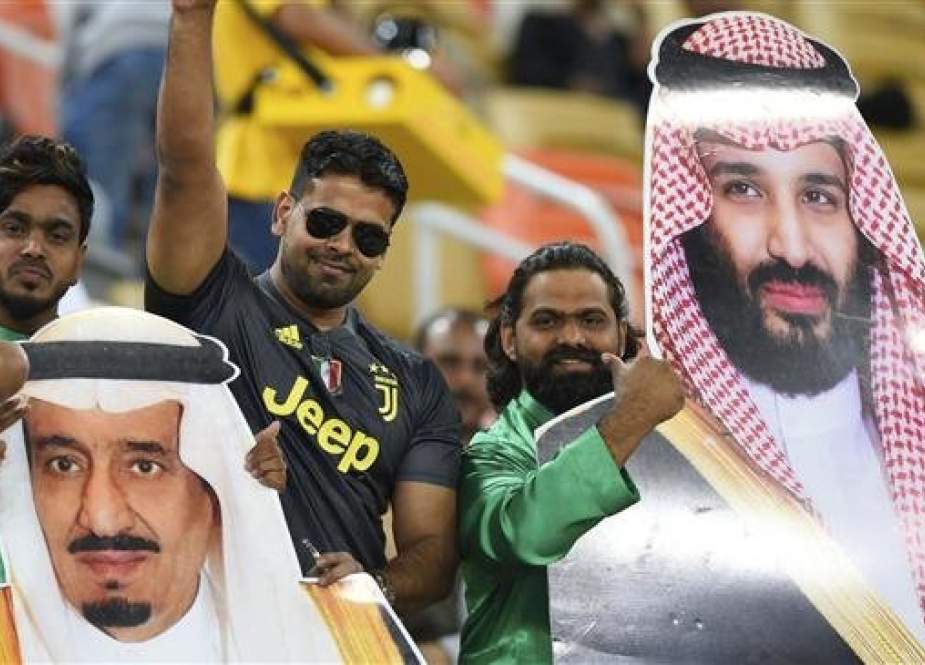Saudi football fans hold pictures of Prince Mohammed (R) and King Salman, who was advised to change his security team on a trip to Egypt. (Photo by AP)