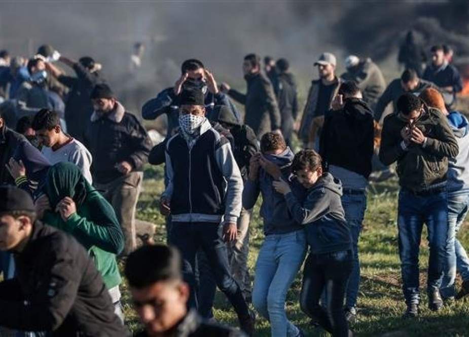 Palestinian protesters react to tear gas fired by Israeli forces during clashes with Israeli forces near Israeli-occupied territories, east of Gaza City, on March 8, 2019. (Photo by AFP)