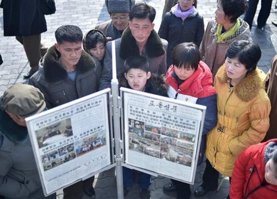 People gather round a news stand to read a copy of the Rodong Sinmun newspaper showing coverage of North Korean leader Kim Jong-un arriving in Vietnam ahead of a Hanoi summit with US President Donald Trump, in Pyongyang on February 27, 2019. (Photo by AFP)