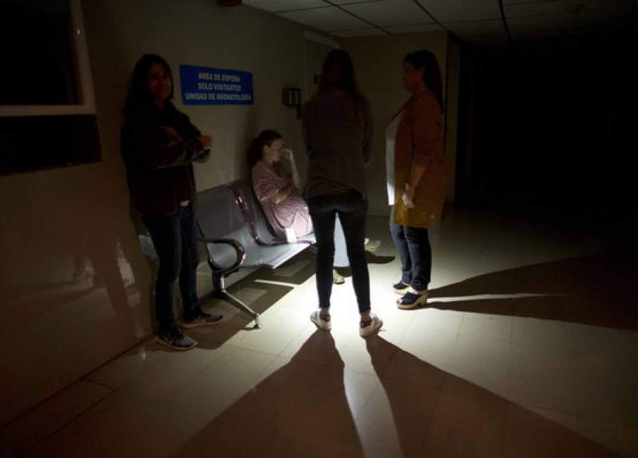 People wait outside of an intense care room for babies at a clinic, during a power outage in the Venezuelan capital Caracas, March 7, 2019.
