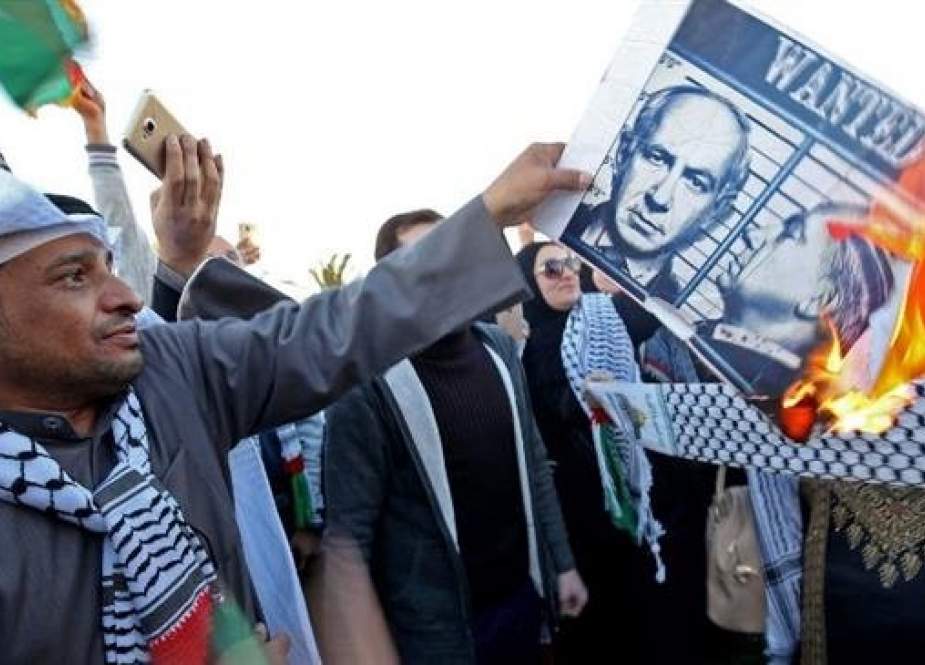 The file photo shows a Kuwaiti demonstrator burning a poster of Israeli Prime Minister Benjamin Netanyahu during a demonstration in front of the National Assembly in Kuwait City on December 9, 2017, against US President Donald Trump