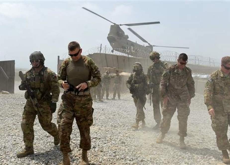US army soldiers walk as a helicopter flies overhead at Forward Operating Base (FOB) Connelly in the Khogyani district in the eastern province of Nangarhar on August 12, 2015. (Photo by AFP)