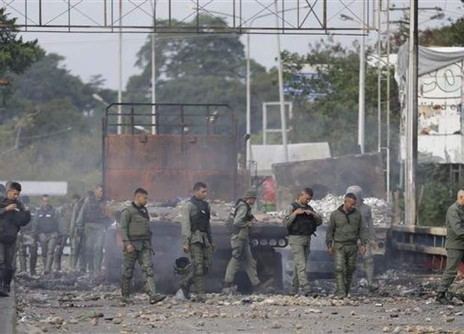 Venezuelan security forces inspect trucks torched.jpg