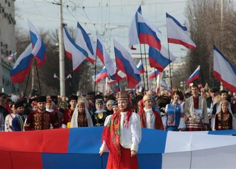 People carry Russian flags during celebrations of the fifth anniversary of Russia