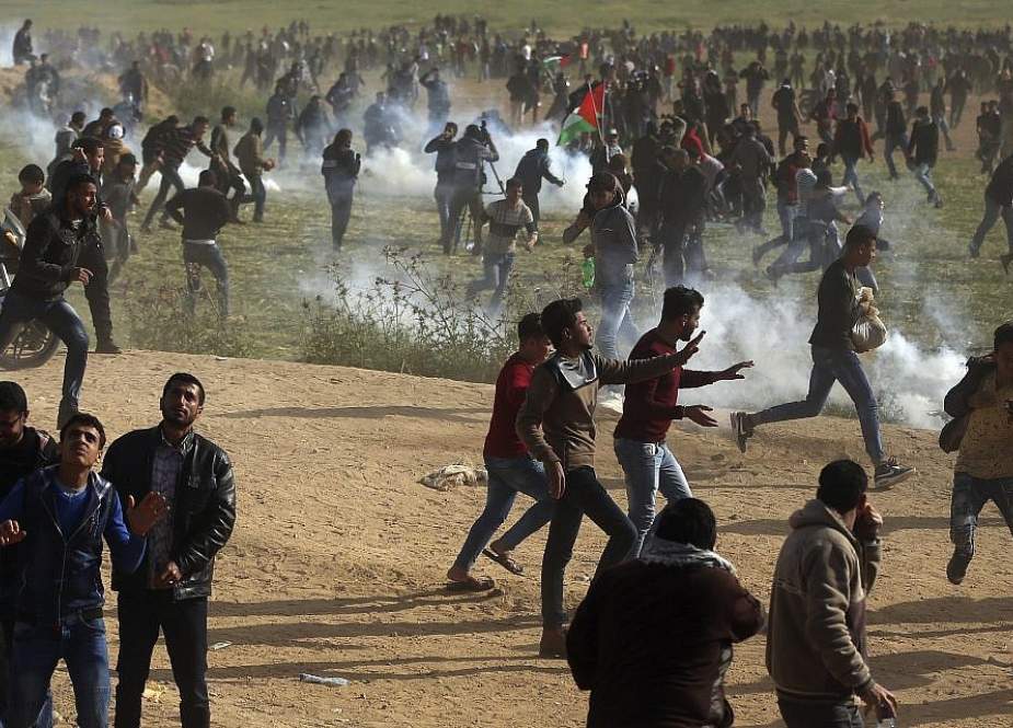 Palestinian demonstrators run away from tear gas during an anti-occupation protest east of Gaza City on February 8, 2019.