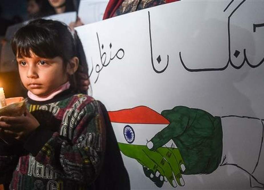Pakistani girl holds a light candle during a vigil for peace in Lahore.jpg