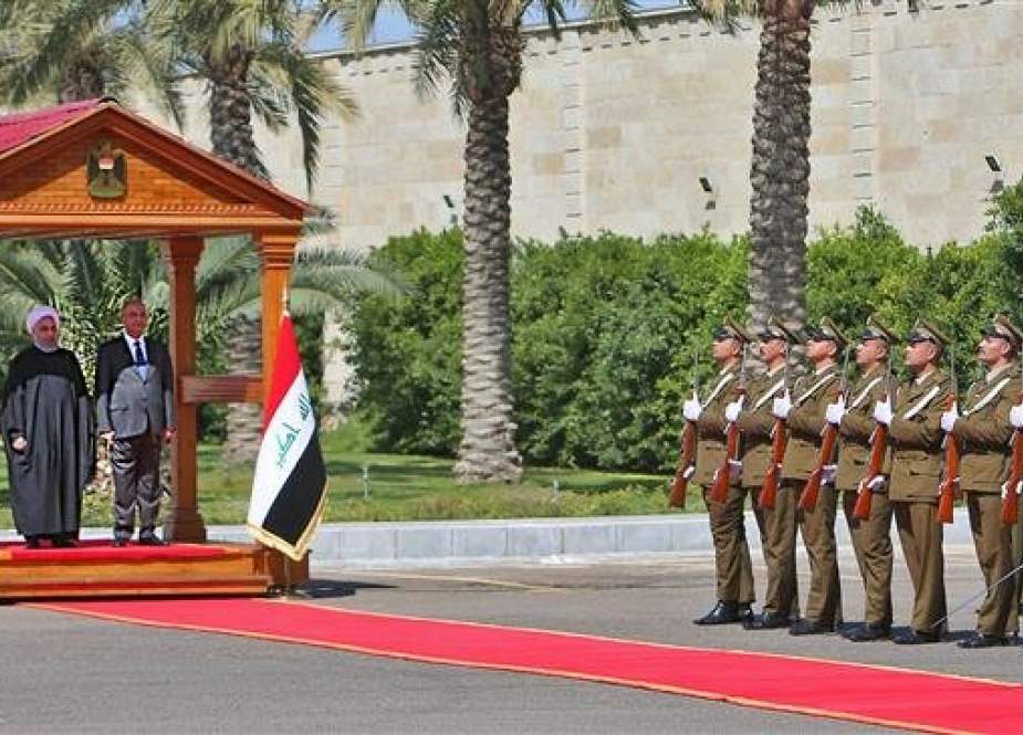 Iraqi President Barham Saleh (R) and his Iranian counterpart, Hassan Rouhani, review the honor guard at the presidential palace in Baghdad, on March 11, 2019. (Photo by AFP)